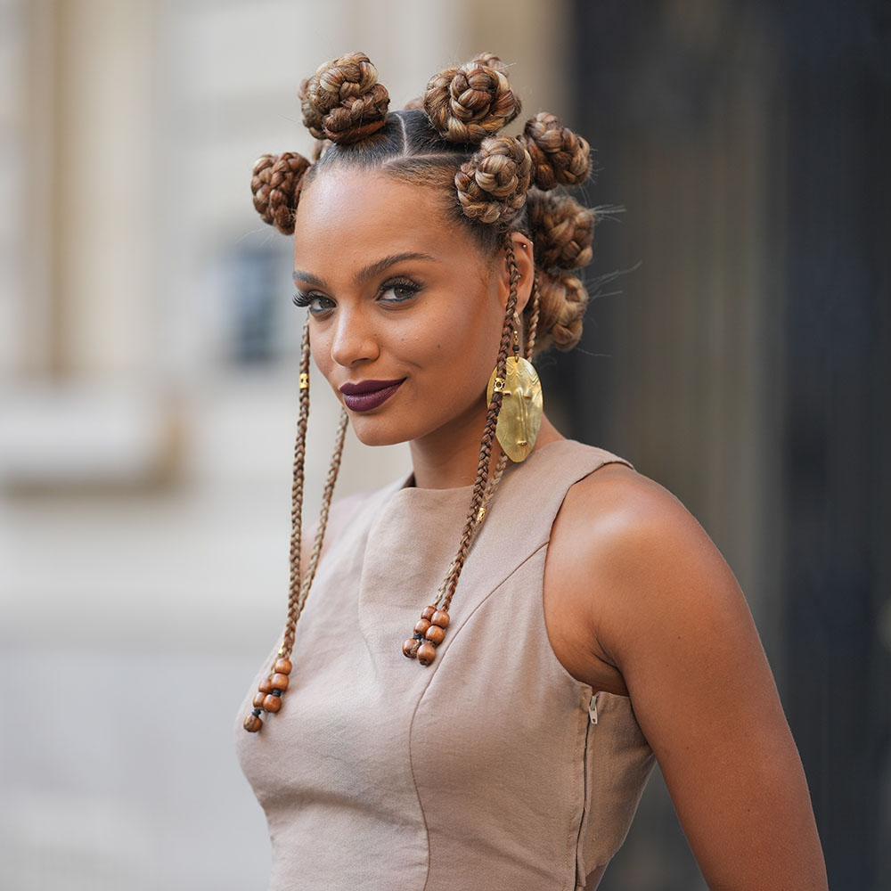Woman with a bantu knot hairsyle wearing gold earrings