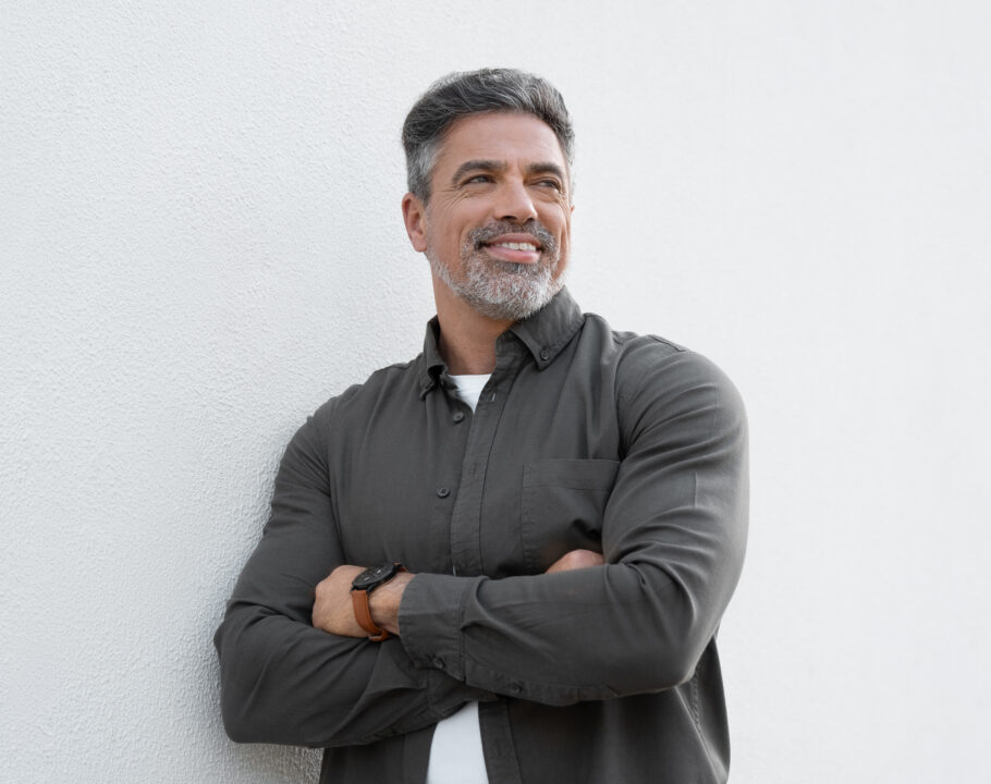 Smiling mature man standing crossed arms isolated on white background