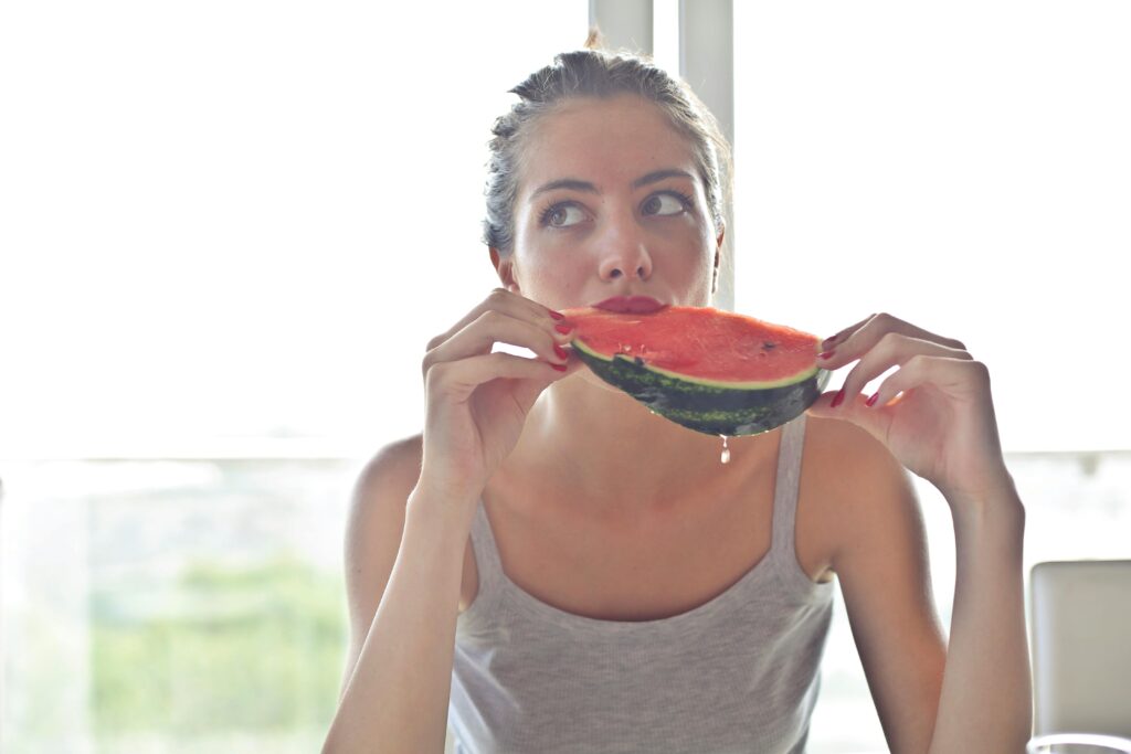 mujer comiendo sand&iacute;a, hidrataci&oacute;n, alimentos saludables
