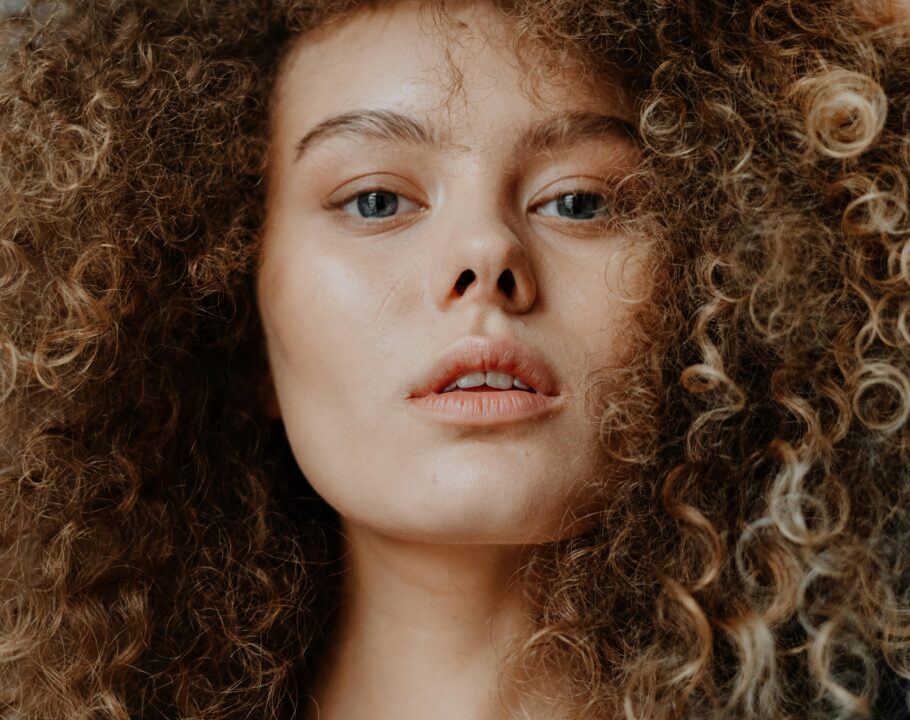 Stunning close-up portrait of a young woman with curly hair, showcasing natural beauty.